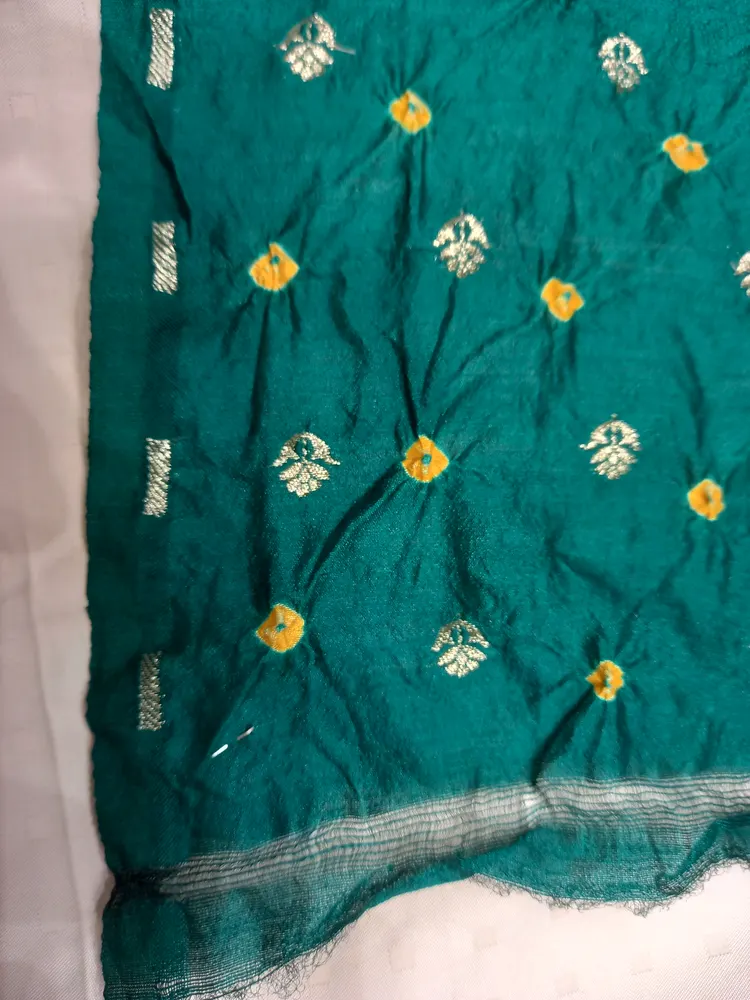 A green Bandhani textile with small contrasting dotted motifs