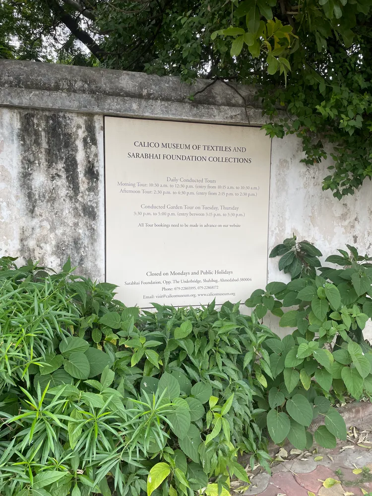 Entrance sign for the Calico Museum of Textiles and Sarabhai Foundation collections among plants