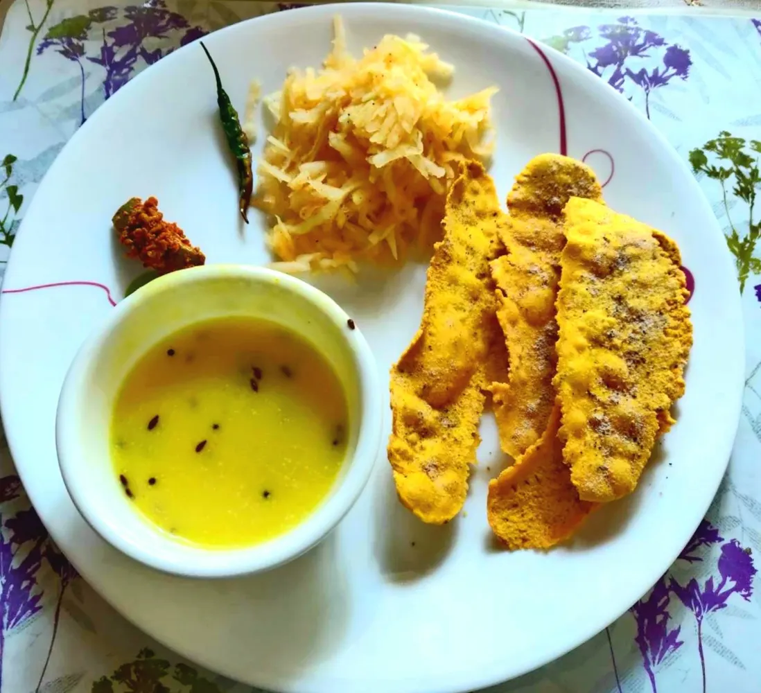 Plate of crisp fafda served with kadhi chutney and shredded papaya accompaniment