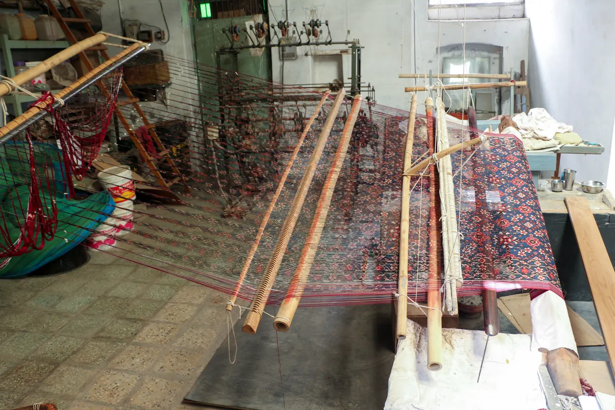 Looms and patterned cloth in a Patola weaving workspace